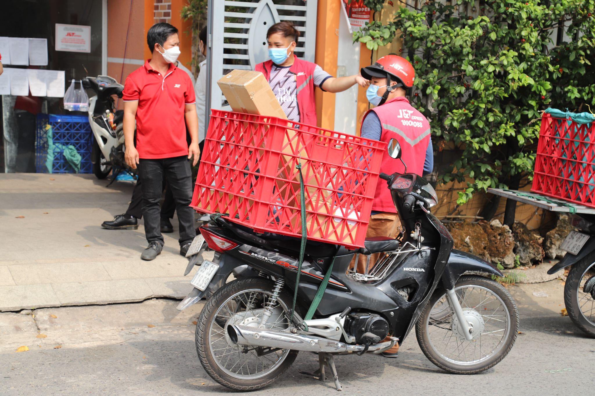 Anh Nguyễn C.L.L Long (bên trái), trưởng bưu cục J&amp;T Express Nguyễn Phúc Chu, TP HCM hỗ trợ công tác giao hàng trong mùa cao điểm. Ảnh: J&amp;T Express Việt Nam