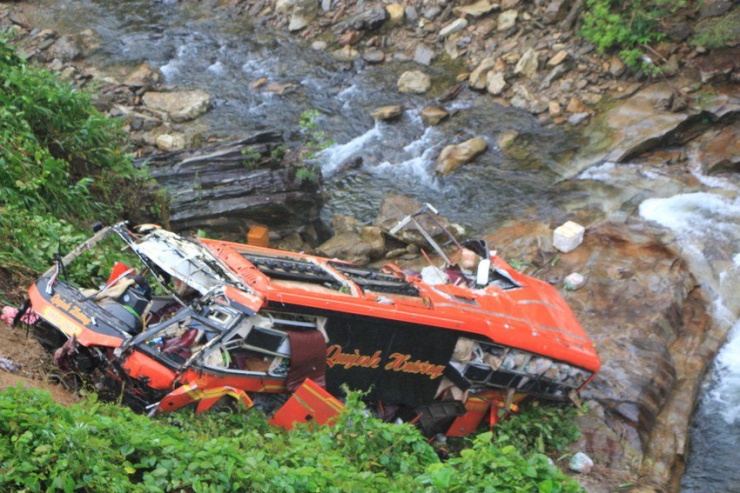 Xe kh&aacute;ch biến dạng sau khi rơi xuống vực s&acirc;u. Ảnh: MINH TRƯỜNG