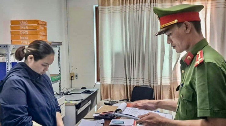 Nguyễn Thị Thu nghe cảnh sát đọc lệnh khởi tố. Ảnh: CA