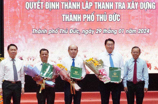 Bí thư Thành ủy Thủ Đức Nguyễn Hữu Hiệp (bìa phải) và Giám đốc Sở Xây dựng TPHCM Trần Hoàng Quân trao quyết định cho các nhân sự chủ chốt của Thanh tra Xây dựng TP Thủ Đức. Ảnh: CTV