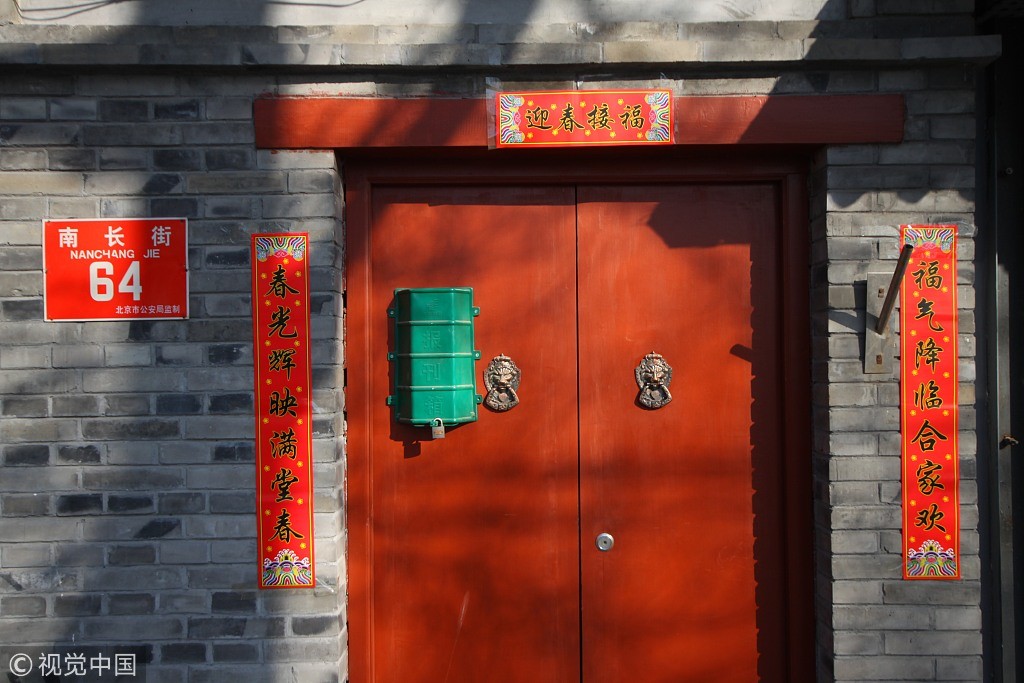 Những câu đối được dán bằng giấy đỏ trên một cánh cửa ở Bắc Kinh dịp năm mới. Ảnh: CGTN.