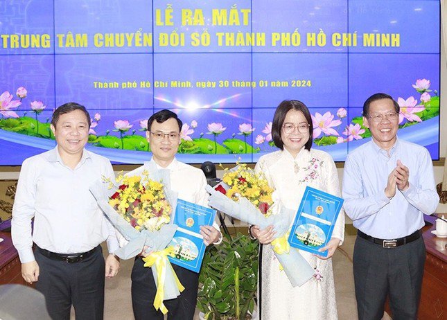 Chủ tịch UBND TPHCM Phan Văn Mãi (ngoài cùng bên phải) và Phó Chủ tịch UBND TPHCM Dương Anh Đức trao quyết định và tặng hoa chúc mừng bà Võ Thị Trung Trinh và ông Nguyễn Đức Chung nhận nhiệm vụ mới.