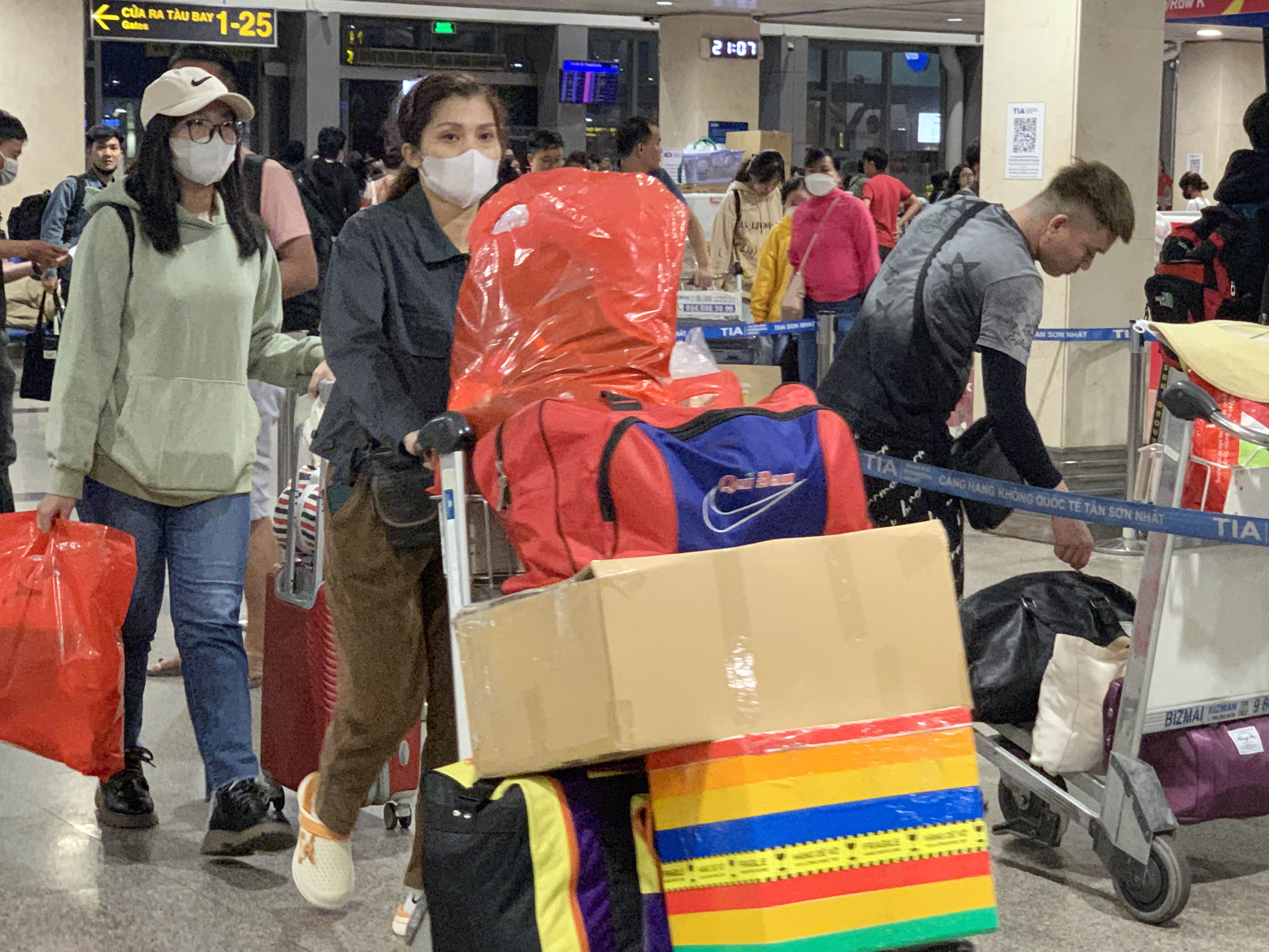 Người dân lỉnh khỉnh hành lý đổ về ga quốc nội sân bay Tân Sơn Nhất để về quê đón Tết cùng gia đình.