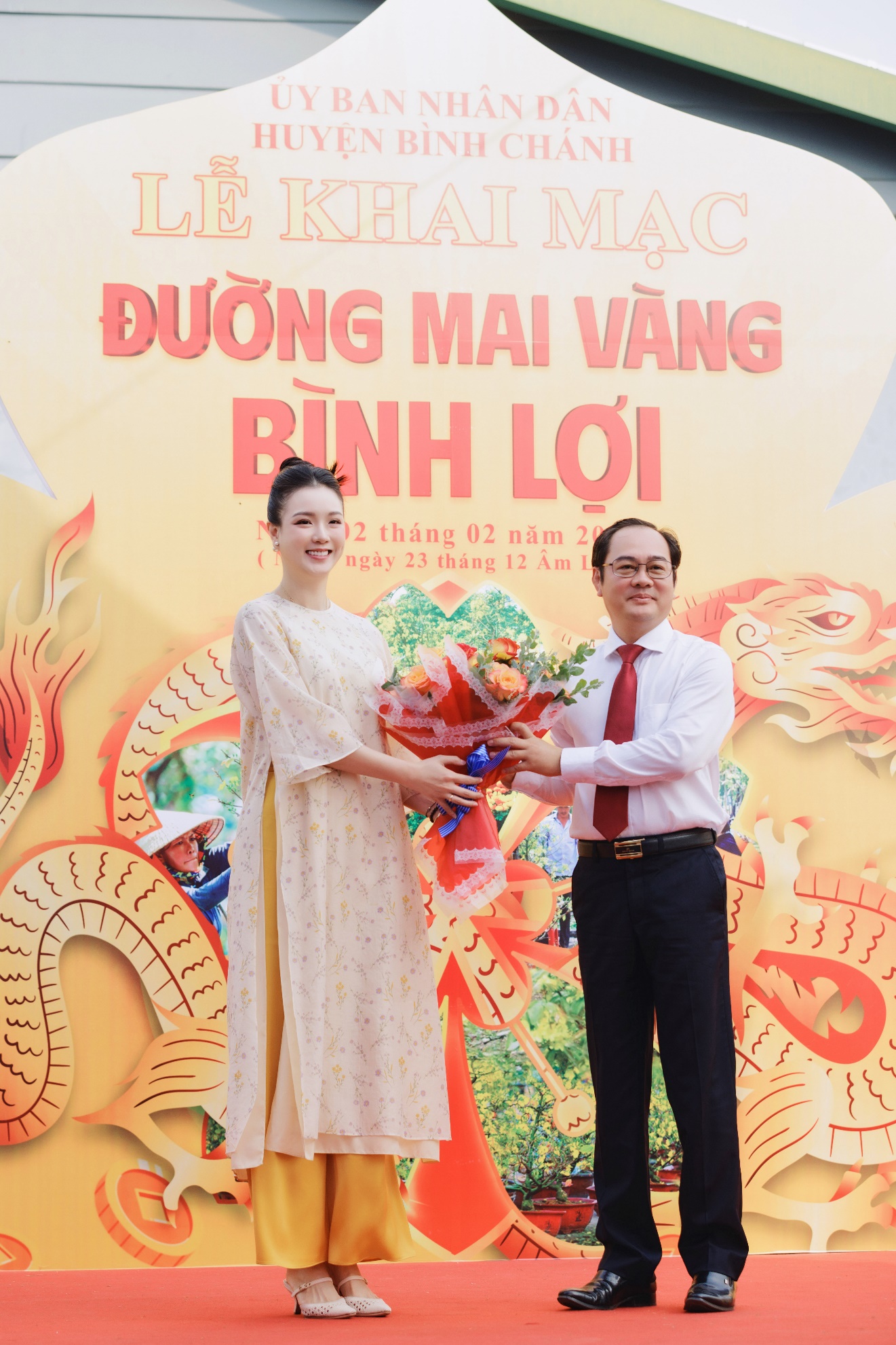 Ông Huỳnh Cao Cường - Phó Chủ tịch UBND huyện Bình Chánh trao hoa cảm ơn đơn vị tài trợ bà Nguyễn Thị Trang Phương – CT. HĐQT Hải Hưng Group