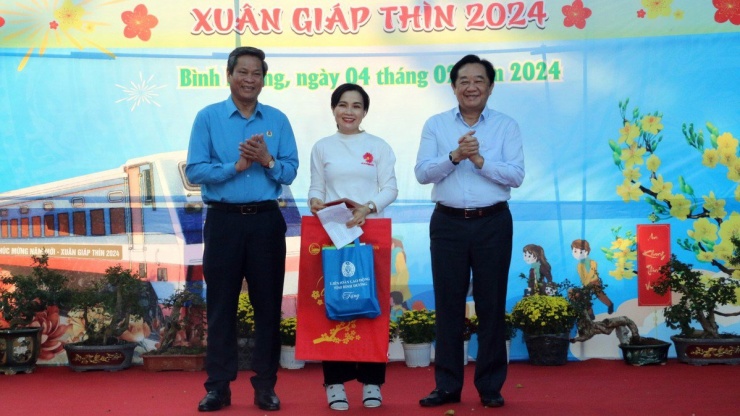 Lãnh đạo tỉnh Bình Dương và lãnh đạo Tổng liên đoàn lao động Việt Nam tặng quà cho công nhân trước khi lên tàu về quê. Ảnh: HT