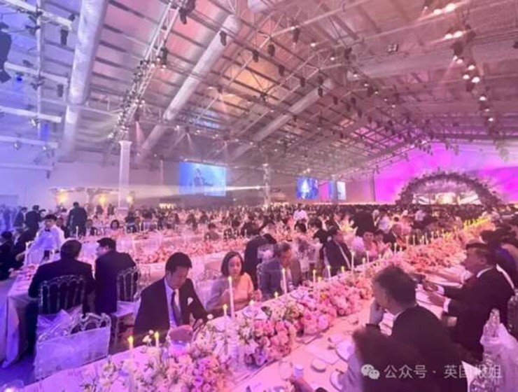 Các bàn tiệc đều được thết kế riêng, hoa tươi tràn ngập khắp nơi và có thể thấy hội trường rộng lớn chật kín quan khách.
