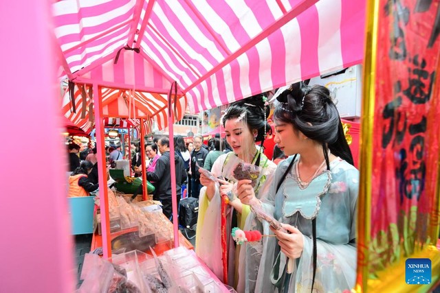 Du khách trong Hán phục truyền thốngchọn đồ ăn nhẹ tại sự kiện chào mừng Tết Nguyên Đán ở phố Temple,phía Nam Hồng Kông (Trung Quốc) hôm 4-2. Ảnh: Tân Hoa Xã