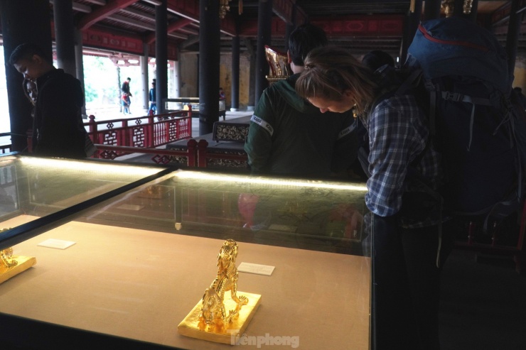 Du khách thưởng lãm các tác phẩm mô phỏng ấn vàng (kim ấn) triều Nguyễn được trưng bày bên trong điện Thái Hòa dịp Tết Giáp Thìn 2024.