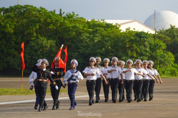 Đội danh dự với Quân kỳ Quyết thắng duyệt binh đi qua lễ đài trước cờ Tổ quốc và cột mốc chủ quyền đảo Trường Sa.