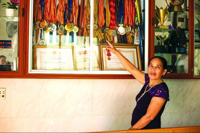 Bà Nguyễn Thị Học bên tủ huy chương của con trai