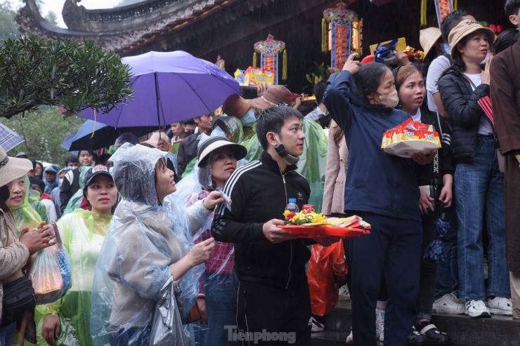 Dù trời mưa to, số lượng người đổ về chùa Thiên Trù không suy giảm. Nhiều người chuẩn bị sẵn mâm lễ nhằm cầu mong một năm mới vui vẻ, hạnh phúc, sức khỏe dồi dào.