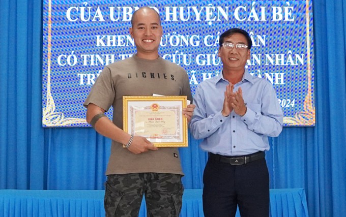 Đại diện UBND huyện Cái Bè trao giấy khen cho anh Phan Quốc Huy. Ảnh: Hoàng Nam