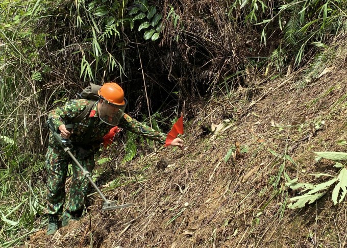 Công binh cắm cờ, đánh dấu vị trí phát hiện tín hiệu vật nổ dưới lòng đất. Ảnh: Hoàng Phong