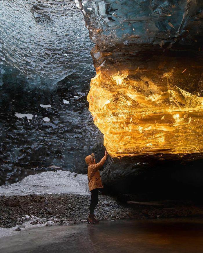 Những tia nắng hoàng hôn chiếu vào một hang băng ở Iceland khiến nó trông như hổ phách.