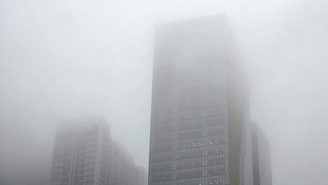 Trong cả buổi sáng nay, hiện tượng sương mù bao phủ xuất hiện càng lúc càng đậm hơn, tầm nhìn bị hạn chế. Các tòa nhà cao tầng chìm trong sương mù bao phủ.