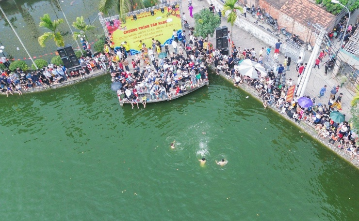 Nhiều khán giả có mặt từ sớm, vây kín xung quanh đầm nước, cổ vũ tinh thần cho các vận động viên của làng.