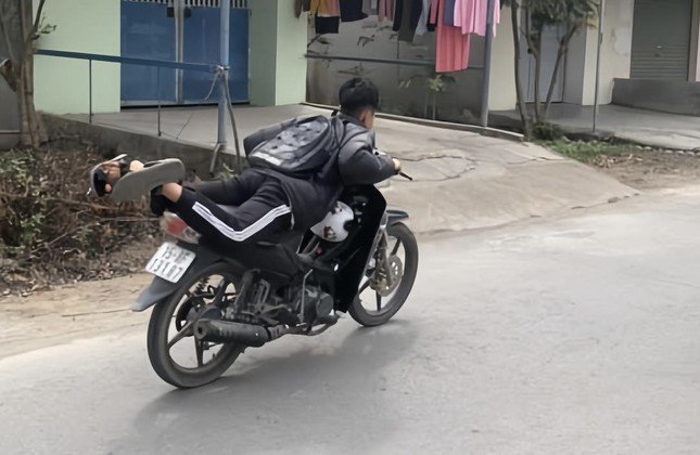 Nam sinh đầu trần, nằm trên yên lái xe máy ở huyện Thủy Nguyên, TP Hải Phòng.