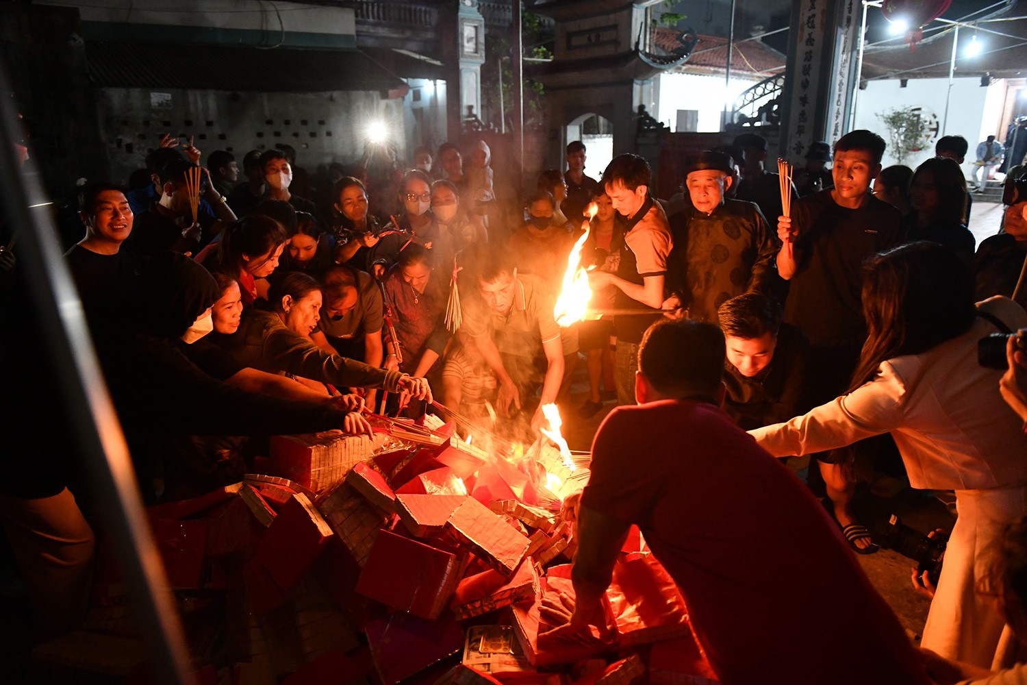  Hàng trăm người dân đứng kín sân để chờ lấy lửa mang về nhà