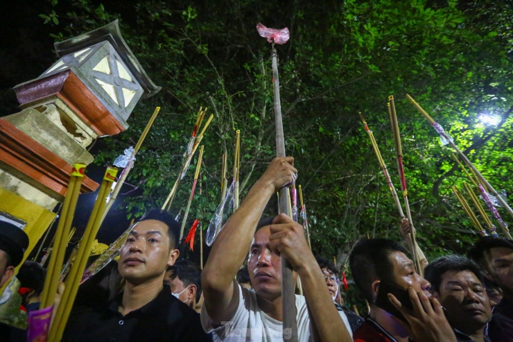 Hàng ngàn người dân và du khách đứng chờ ở khu lăng mộ Chu Bá dùng sào tre buộc hương để lấy chuẩn bị lấy lửa thiêng.