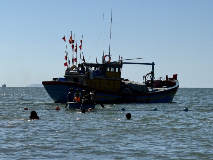 Ngư dân hỗ trợ thuyền kéo phao cá ra khu vực nước sâu ở Phao số 0.
