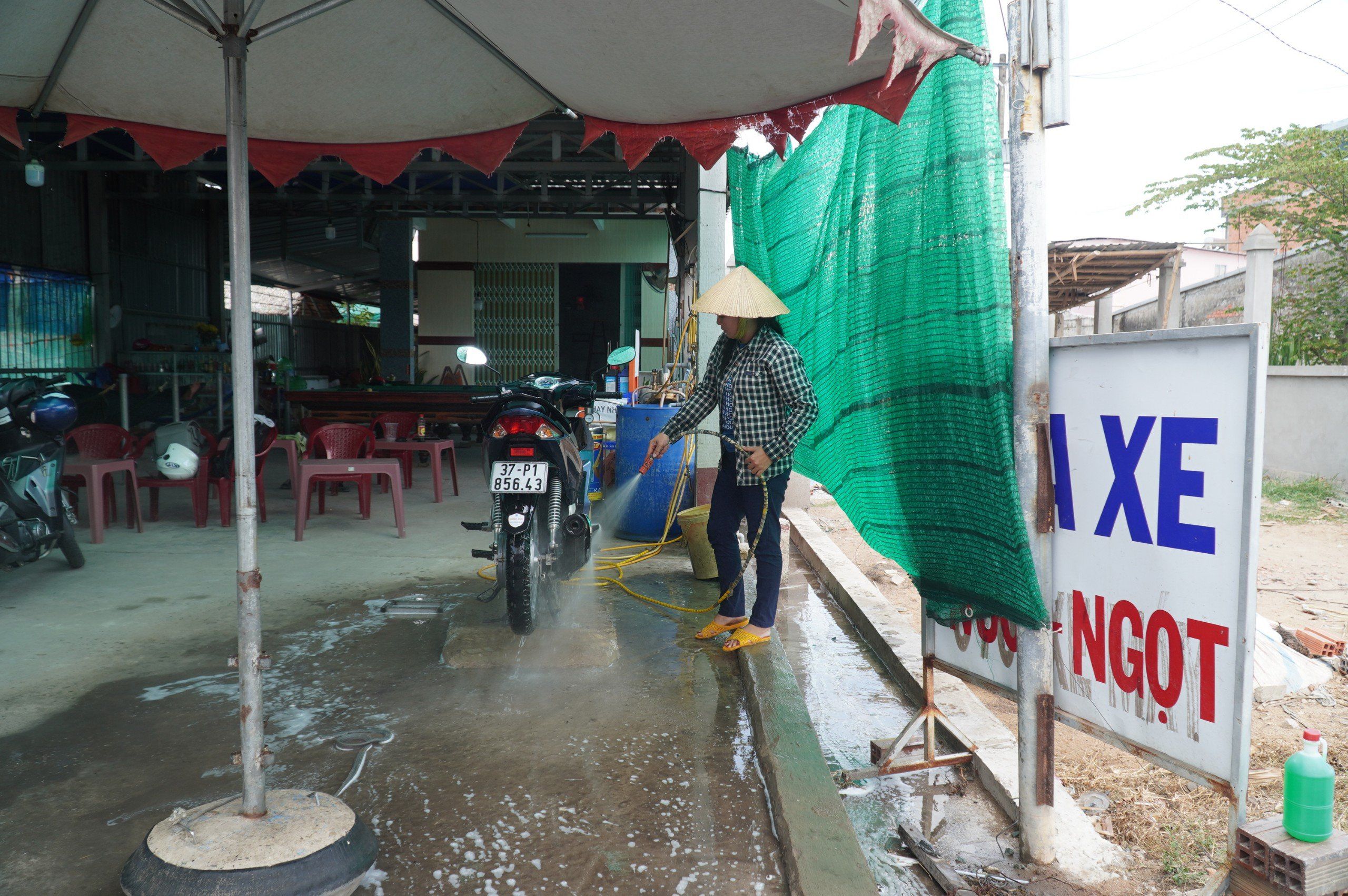 Quán rửa xe của chị Quỳnh phải mua nước ngọt về để rửa xe cho khách, tăng thêm 5.000 đồng/lượt rửa xe.