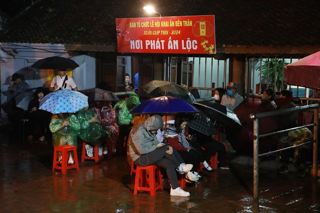 Tại sân Thiên Trường, nhiều người ngồi đợi trong mưa rét.