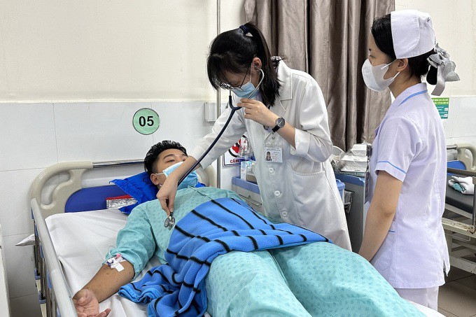 Bác sĩ Bệnh viện Bình Dân thăm khám cho chàng trai 23 tuổi trước khi lọc máu. Ảnh: Trần Nhung