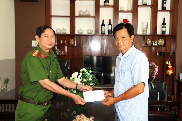Đại tá Trần Văn Hòa (trái), Phó Giám đốc Công an tỉnh Sóc Trăng, thăm hỏi, động viên trung tá Lê Văn Hưng. Ảnh: CAST