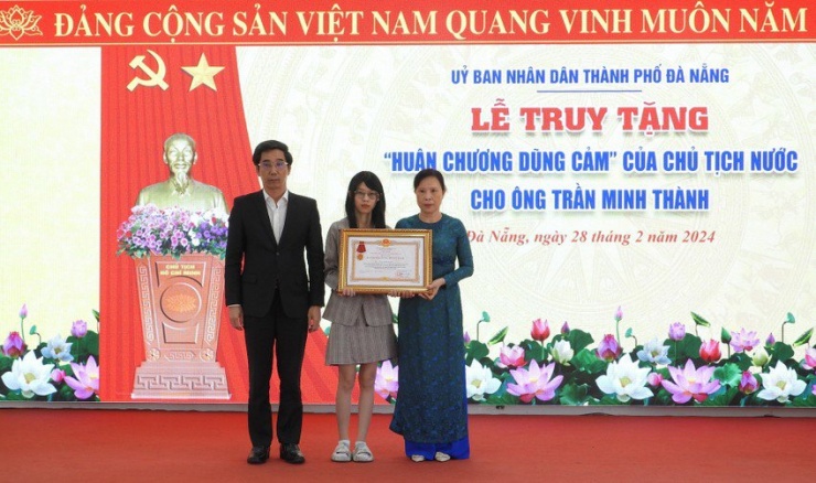 Gia đình đón nhận Huân chương dũng cảm cho ông Trần Minh Thành. Ảnh: DH.