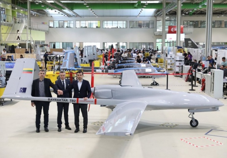 Một chiếc Bayraktar TB2 cùng hai ông Haluk Bayraktar (trái ngoài cùng) và Selcuk Bayraktar (phải ngoài cùng).
