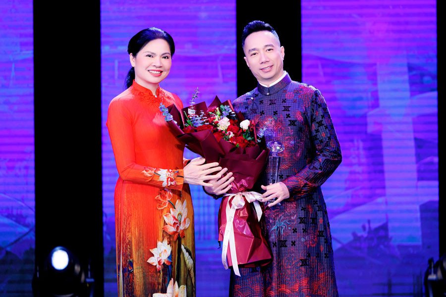Nhà thiết kế (NTK) Đỗ Trịnh Hoài Nam đại diện 57 NTK đến từ 3 miền Bắc - Trung - Nam lên nhận hoa kỷ niệm.&nbsp;