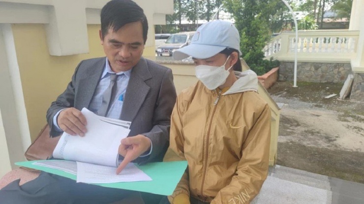 Luật sư Nguyễn Thanh Kha (bảo vệ miễn phí cho bà Dung) trao đổi với bà trước khi vào phiên tòa. Ảnh: NGUYỄN HIỀN