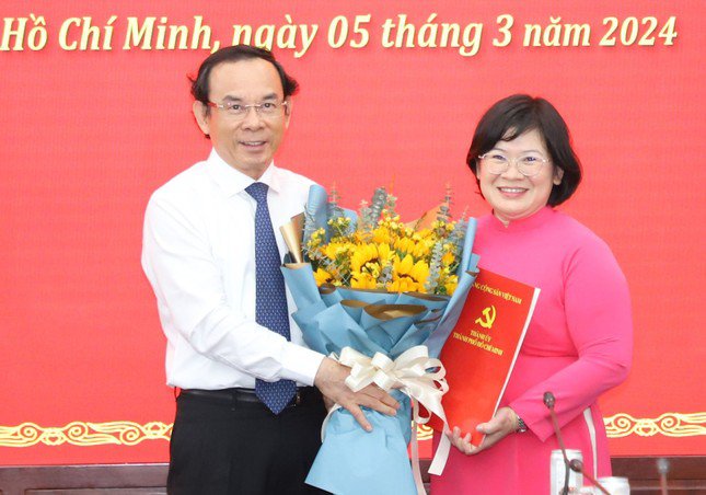 Bí thư Thành ủy TPHCM Nguyễn Văn Nên trao quyết định và hoa chúc mừng bà Văn Thị Bạch Tuyết. Ảnh: Ngô Tùng.
