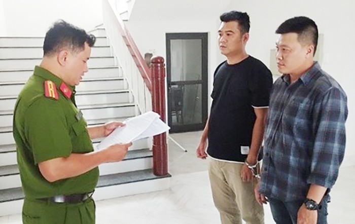 Cơ quan Công an đọc lệnh bắt giữ Nguyễn Thanh Tú (bìa phải) và Nguyễn Văn Nghĩa.