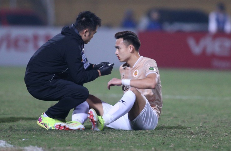 Việt Anh (bên phải) bị đau rời sân sau pha va chạm mạnh ở phút thứ 7