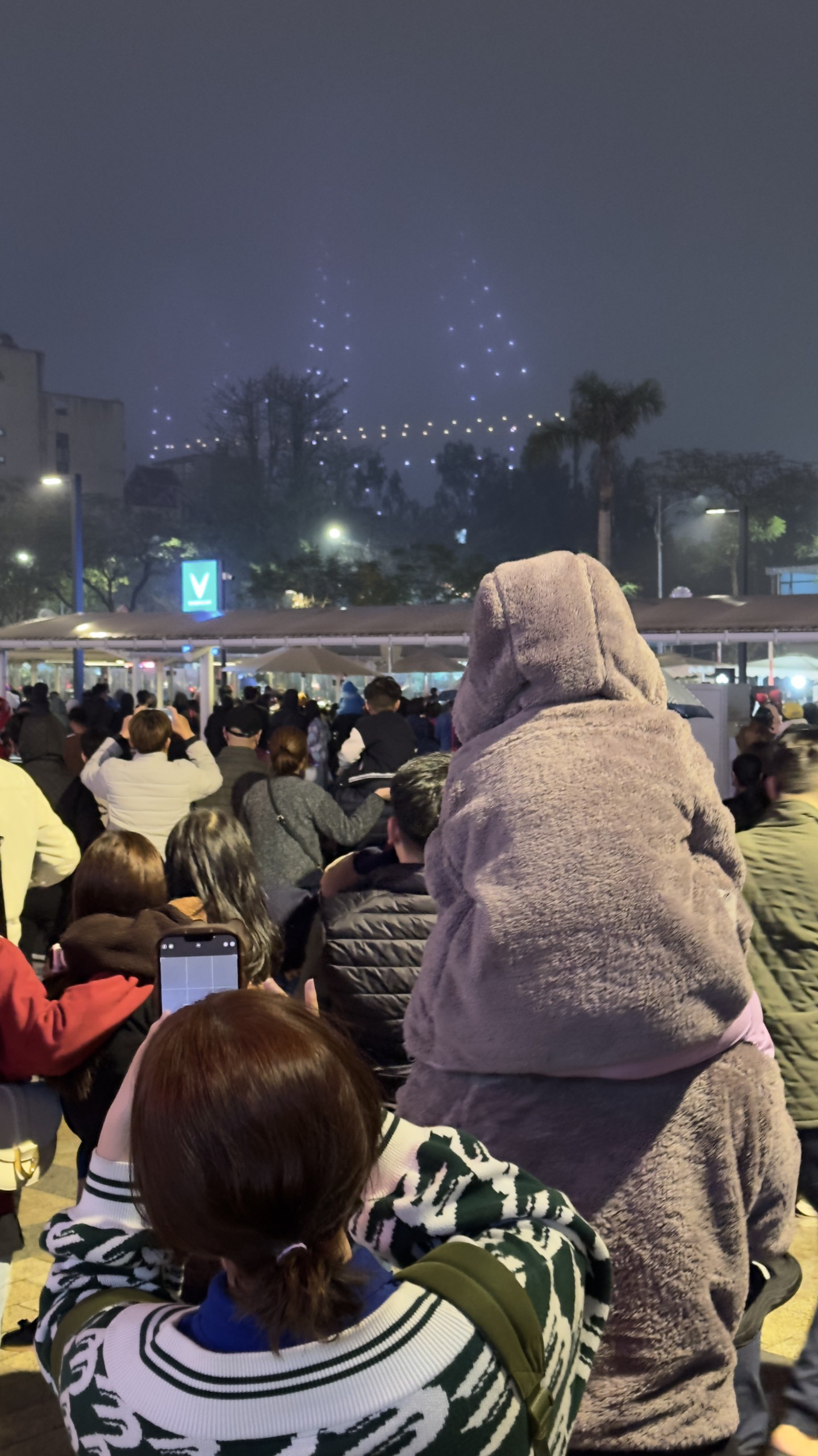 Không thể di chuyển ra phố Trịnh Công Sơn, hàng nghìn người dân Hà Nội tập trung trước sảnh khu phước hợp Lotte Mall để theo dõi màn trình diễn ánh sáng từ xa.