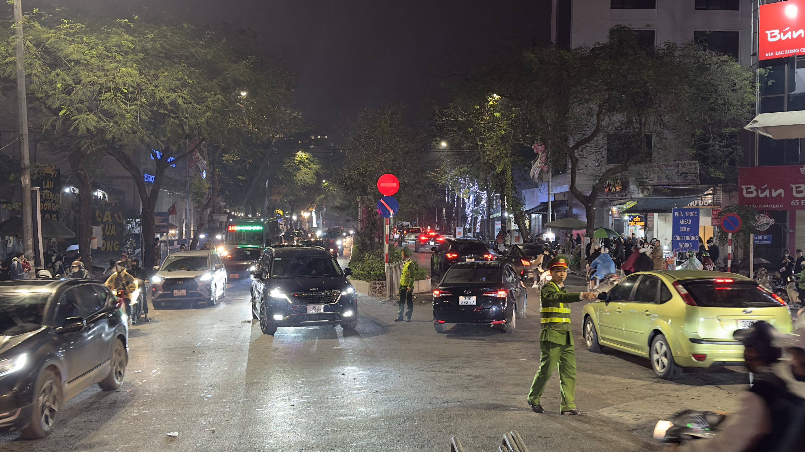 Gần 12h đêm, lực lượng cảnh sát Công an quận Tây Hồ vẫn căng mình phân luồng, hướng dẫn các phương tiện lưu thông.