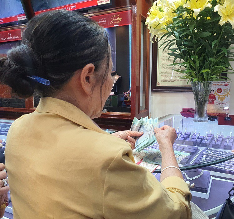 Một khách hàng đếm lại tiền trước khi mua vàng.