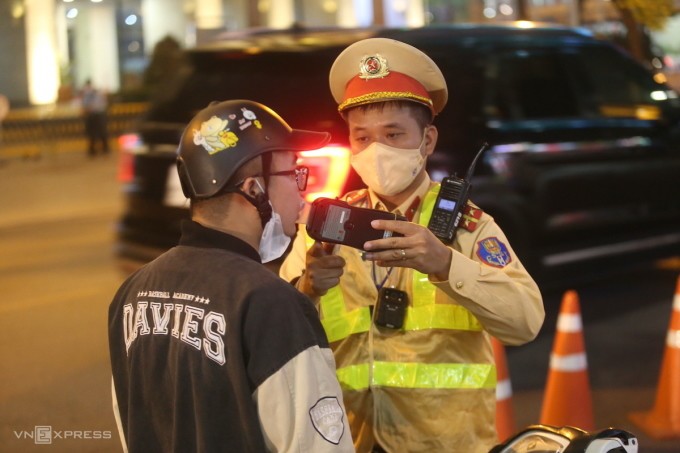 Cảnh sát đo nồng độ cồn người đi xe máy ở đường Huỳnh Thúc Kháng, Hà Nội, tháng 11/2023. Ảnh:Gia Chính