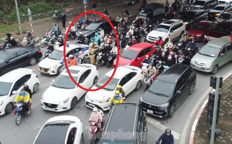 Khi ùn tắc từ tất cả các hướng đến nút giao đại lộ Thăng Long với Lê Quang Đạo, CSGT làm việc tại đây bị các dòng phương tiện ùn tắc vây kín (vòng tròn đỏ).