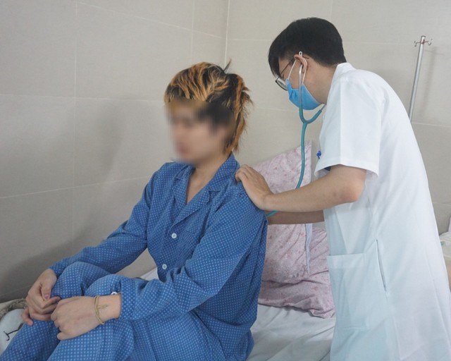 Bác sĩ Nguyễn Trọng Hưng đang khám cho bệnh nhân mắc cúm điều trị nội trú tại Bệnh viện. Ảnh: N.Mai