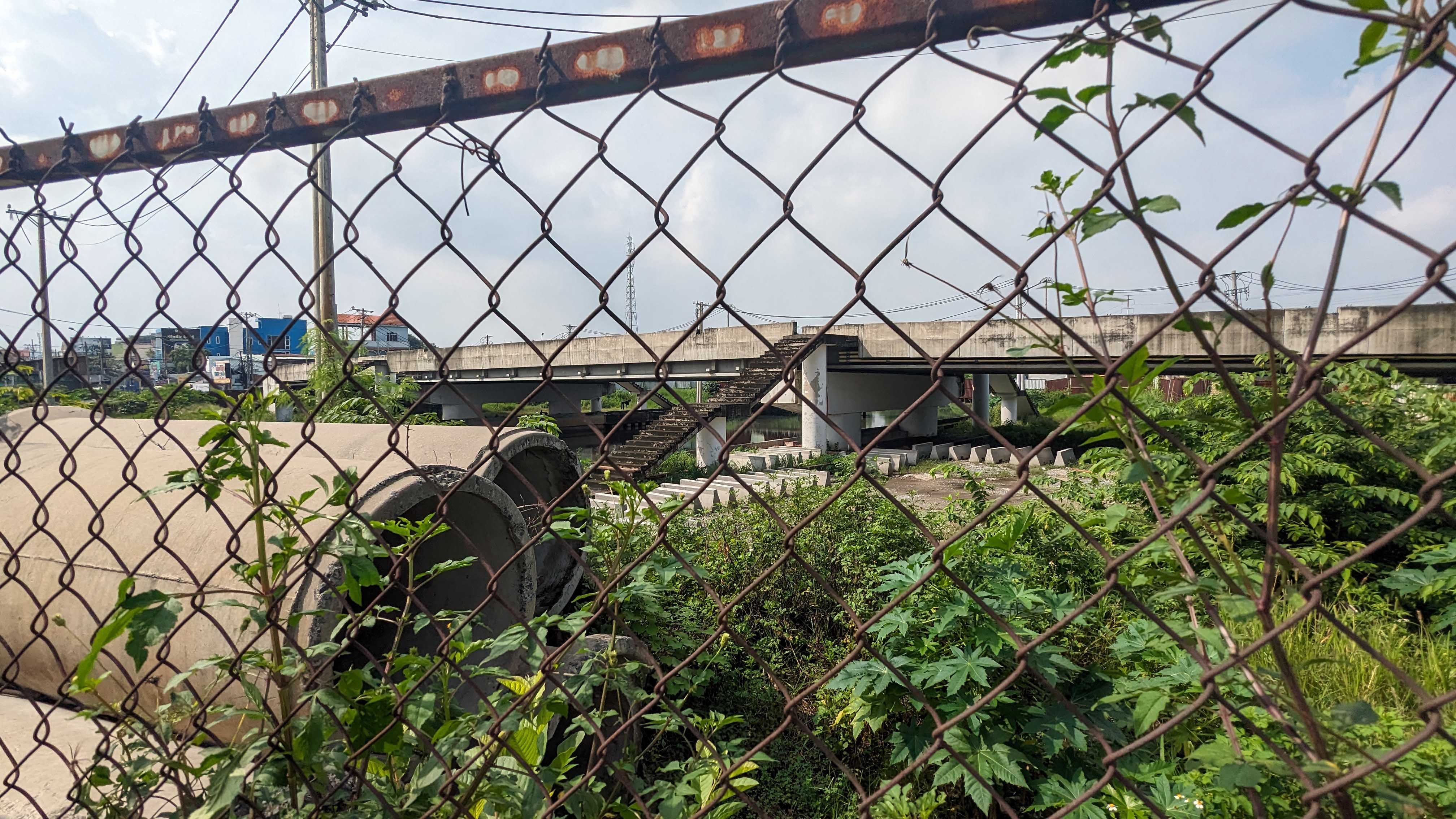 Xung quanh công trình rào chắn ngổn ngang vật liệu xây dựng, ống cống, bêtông bị cỏ bao phủ.