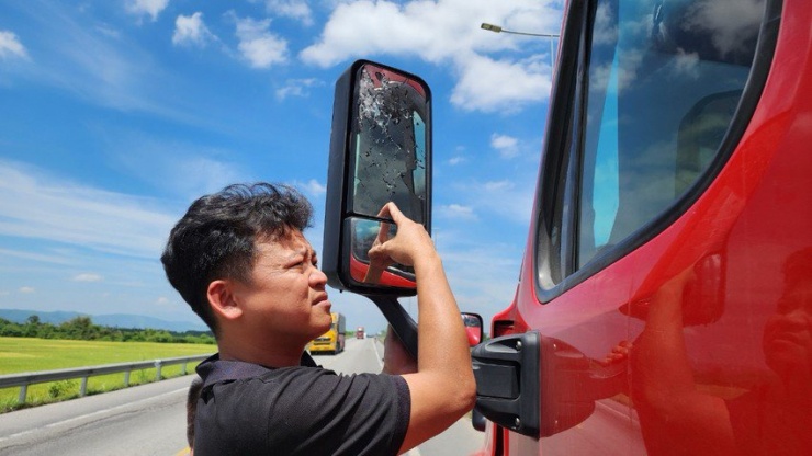 Kẻ xấu chặn đầu, ném đá làm vỡ gương chiếu hậu. Ảnh: AP