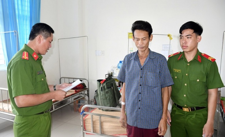 Cán bộ điều tra Công an tỉnh Trà Vinh tống đạt quyết định khởi tố bị can đối với Nguyễn Minh Phong.
