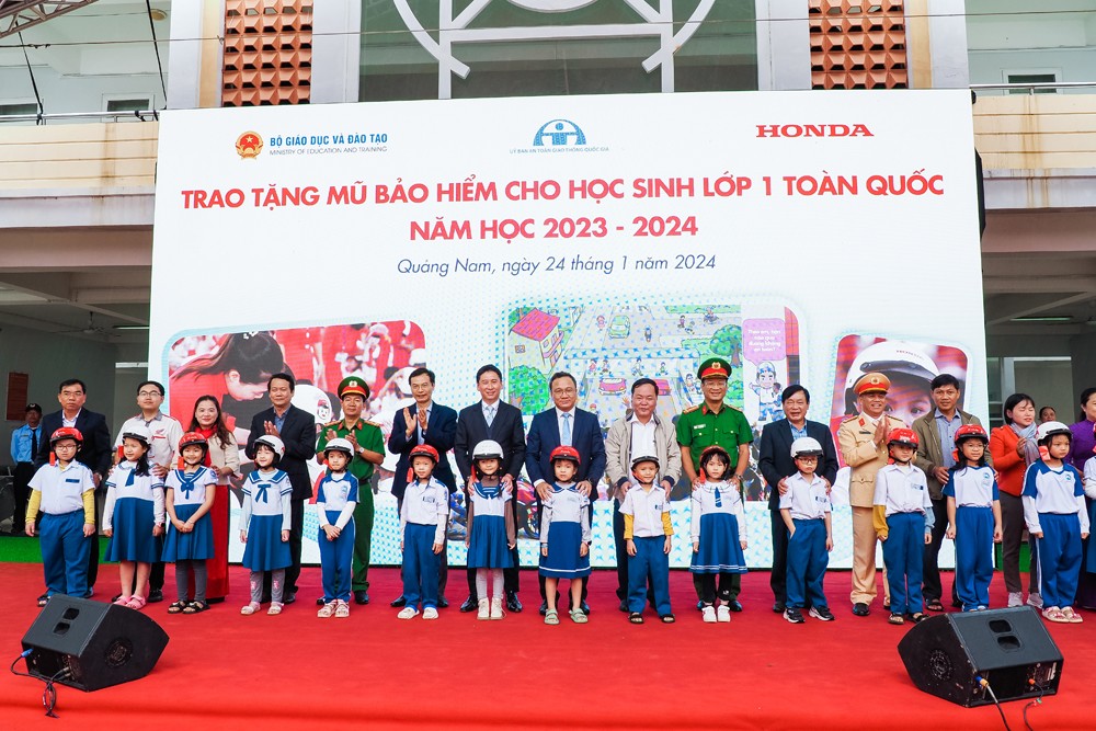 Các đại biểu trao tặng mũ bảo hiểm cho các em học sinh lớp Một trường Tiểu học Võ Thị Sáu