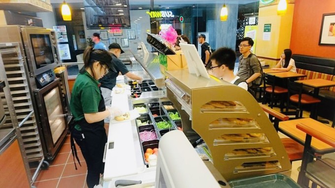 Học sinh Việt Nam làm thêm tại một tiệm bánh mỳ ở Singapore. Ảnh: Đinh Hoàng Hà