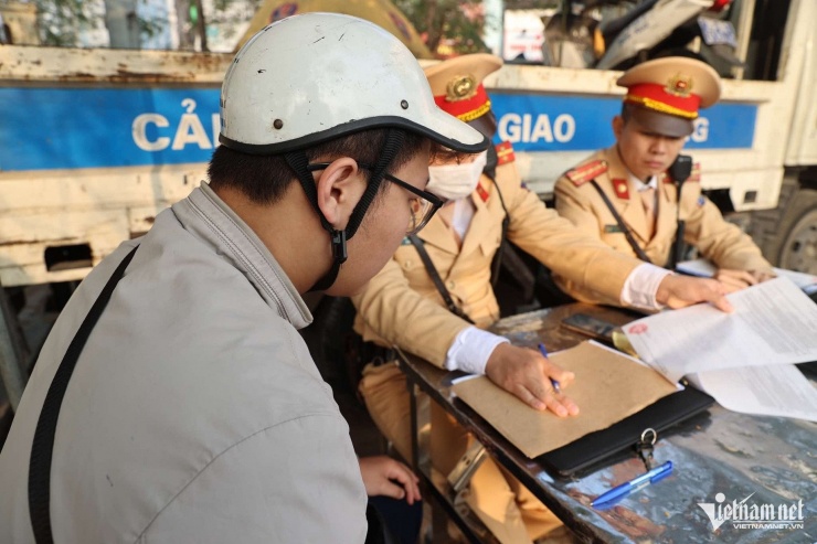 CSGT lập biên bản với lái xe Đ.Đ.V.
với lỗi đè vạch sơn khi dừng đèn đỏ.