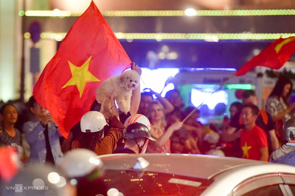 Một chú chó được chủ công kênh ăn mừng trên đường Đồng Khởi, quận 1. Ảnh: Thanh Tùng