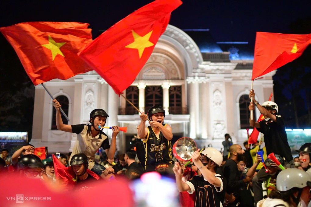 Hàng nghìn người tập trung trước Nhà hát Thành phố mừng chiến thắng đội tuyển. Những người chạy xe ngang đường dừng lại cổ vũ, reo hò trong tiếng kèn, tiếng trống. Ảnh: Thanh Tùng