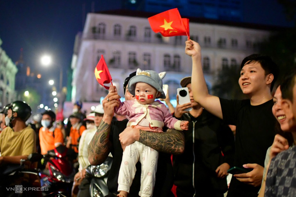 Bé Cherry 13 tháng tuổi được bố chở từ Bình Thạnh tới cổ vũ bóng đá trước Nhà hát Thành phố. Ảnh: Thanh Tùng